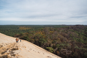 Obraz premium footprints in the sand, in black boots and brown coat, walking in the dunes.