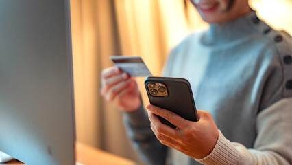 Online payment, Close up - Hands of woman holding a credit card and using smart phone for online shopping