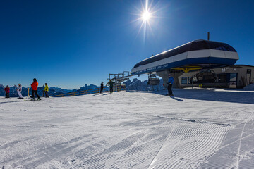 Falcade, Italy - February 15, 2023: At a lift station in the mountains of the Dolomites. Skiers...