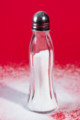 Salt shaker on red background
