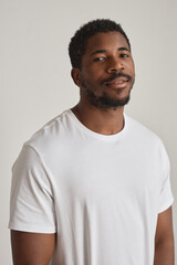 Minimal portrait of handsome black man posing against white vertical