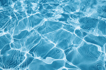 Abstract water background with ripples. Light caustics effect. Play of light and shadow, texture of twaves and splashes.