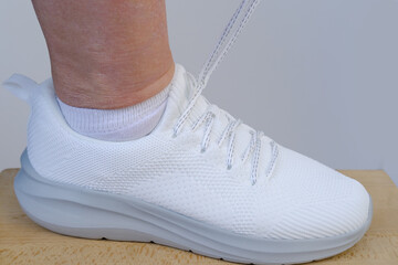 white summer sneakers close-up, female hands test shoes, tie shoelaces, Shoe Care, Fitness and...