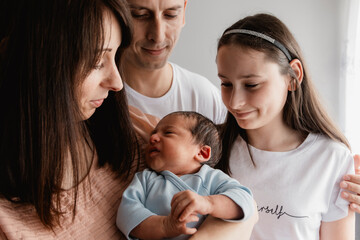 A happy family with a newborn child on her hands (selective focus)