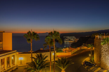 Beautiful exterior view of hotel at Gran Canaria on backdrop of sunset in Atlantic Ocean. Spain.  - obrazy, fototapety, plakaty