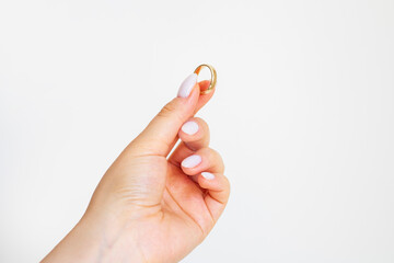 Hand holding a gold ring isolated on white background.