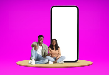 Relaxed black lovers chilling on platform next to huge phone