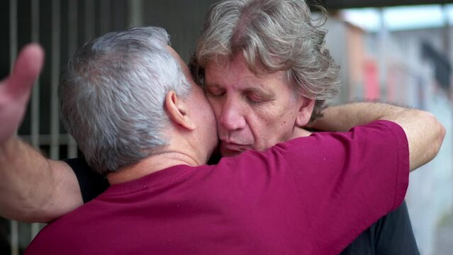 Heart-warming embrace between two senior friends in authentic loving hug. Two elderly people saying farewell embracing, candid and real life family affection