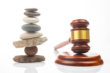 pyramid of stacked stones and a gavel of justice and law on a white background. stabilization and...