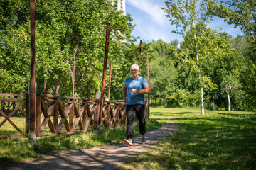 gray-haired man 50 years old jogging in the park in summer