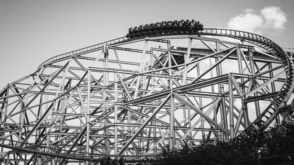 Black and White Roller Coaster with Passengers at the Peak — Dramatic Silhouette and Thrill Atmosphere