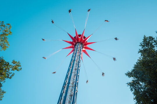 A spinning extreme attraction against the blue sky in the amusement park of the city of St. Petersburg.