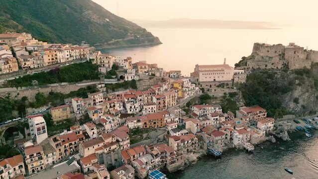 Aerial view of Scilla  at sunset,, with blue sea and castle Ruffo on the rocks, Reggio Calabria, Calabria, Italy.