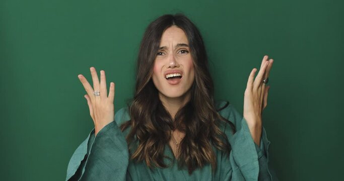 Young girl hands folded in prayer something good, keep fingers crossed, making wish, upset, sad lost at last isolated on green background studio.