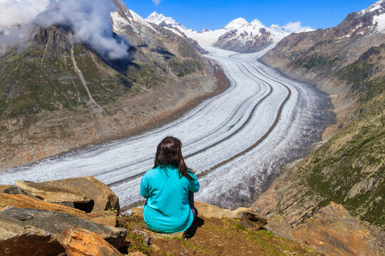 Young woman enjoying the stunning view of the Great Aletsch Glacier in Valais canton, Switzerland