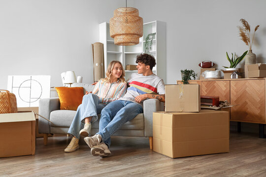 Young couple sitting in room on moving day