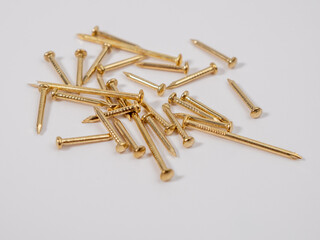 Small furniture nails of gold color on a white background. Nails close-up.