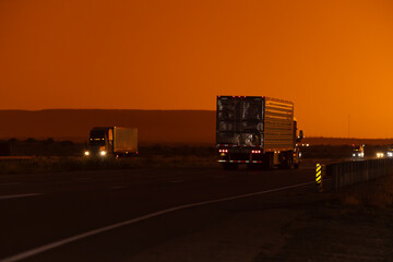 Freight delivery truck transporting cargo on interstate freeway at stunning sunset
