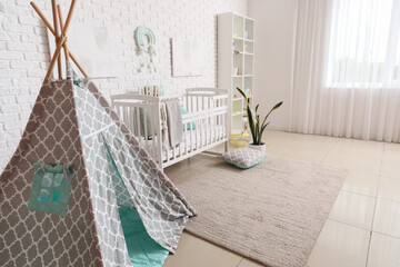 Fototapeta na wymiar Stylish modern interior of children's room with baby bed and play tent
