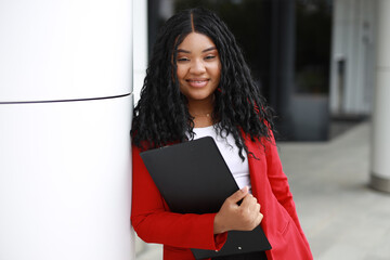 Fototapeta premium portrait of a happy african woman with a black folder in her hands