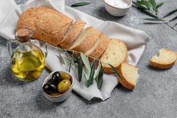 Ciabatta bread sliced olives and olive oil, top view