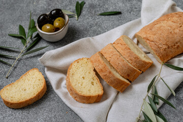 Ciabatta bread sliced olives and olive oil, top view