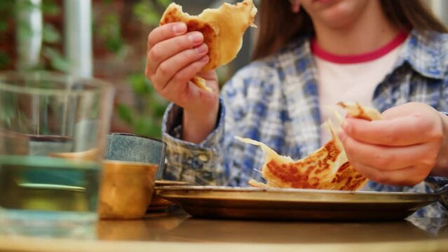 Tourist woman eating Assorted indian Sri Lankan food set on wooden background. Dishes and appetisers cuisine, rice, paneer, samosa, spices, masala. Bowls and plates with indian food top view chicken