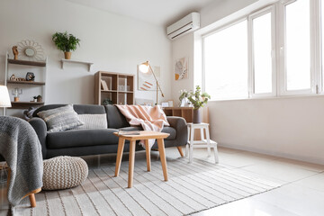 Interior of light living room with glowing lamps and sofa