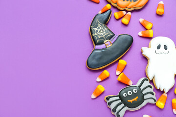 Tasty Halloween candy corns and cookies on purple background