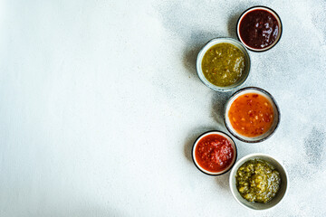 Bowls with traditional Georgian sauces: green plum Tkemali sauce, tomato and cilantro Satsebeli sauce, Kiwi satsebeli