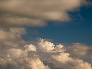 Fototapeta na wymiar Single fluffy cloud over sunset sky background. Fluffy cumulus cloud shape photo