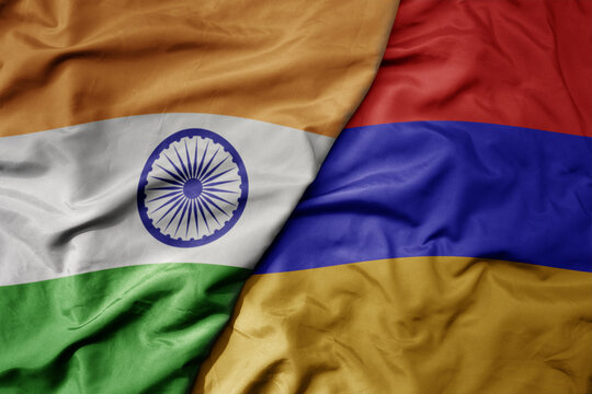 big waving realistic national colorful flag of india and national flag of armenia .
