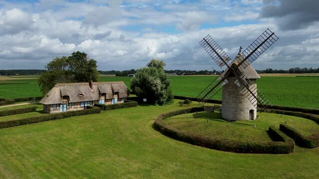 Maison typique normande et son moulin &agrave; vent en pierre.