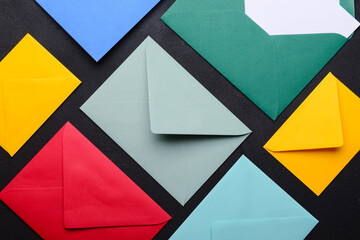 Composition with colorful envelopes on dark background, closeup