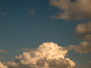 Single fluffy cloud over sunset sky background. Fluffy cumulus cloud shape photo