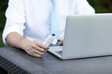 Close-up of businessman holding optional removable router to enhance the signal on a laptop for...