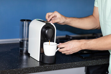 Fototapeta na wymiar Man making coffee in coffee machine at home