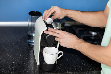 Fototapeta na wymiar Man making coffee in coffee machine at home