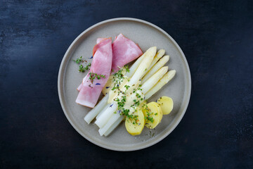 Traditionell gedämpfter weißer Spargel mit Wacholderschinken und Salzkartoffel in Sauce...