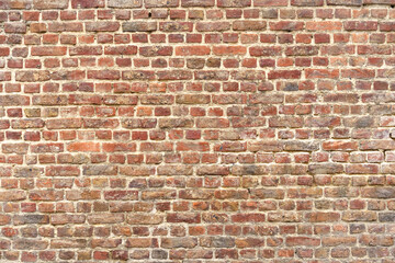 Old red brick wall with different shades. Texture of a brick wall