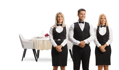 Fototapeta premium Servers in uniforms posing in front of a restaurant table