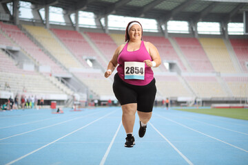 Fototapeta na wymiar Overweight woman running a race at a stadium