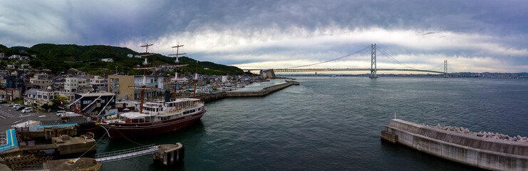 Panoramic view of historic sailing ship anchored at port by modern bridge - 630108125