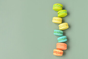 Sweet macaroons on green background