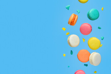 Flying sweet macaroons on blue background