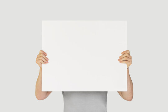 Man showing blank white big A2 paper. Leaflet presentation