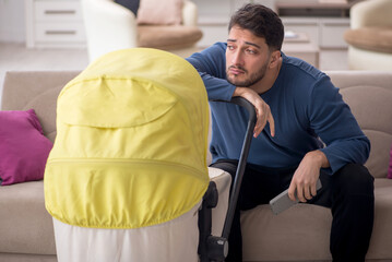 Young man looking after newborn at home