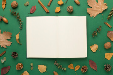 Autumn leaves with notebook on color background, top view