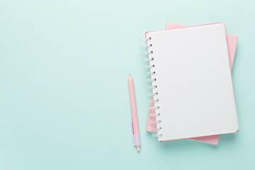Notebooks with stationery on color background, top view