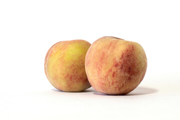 Two isolated peaches on a white background.